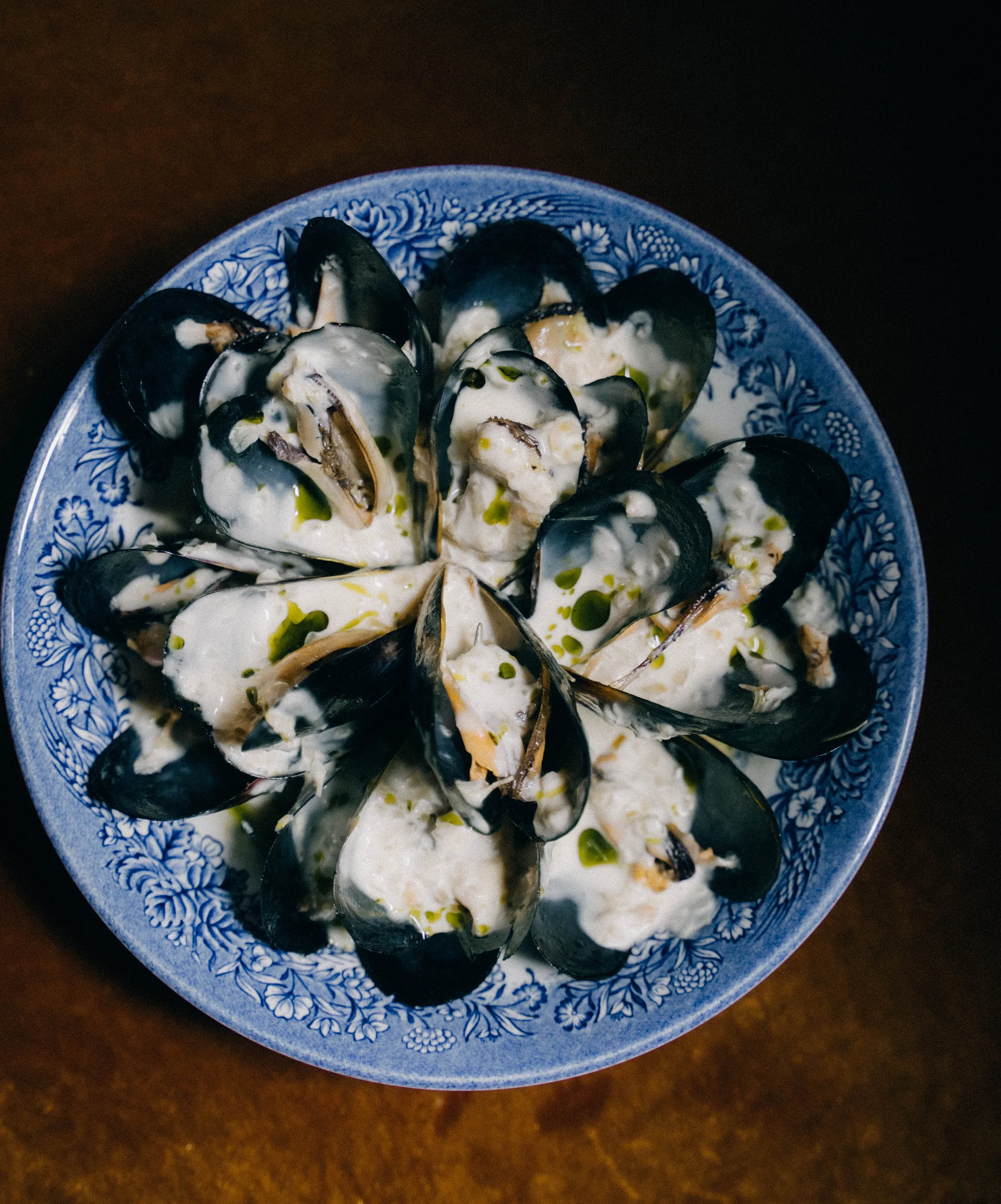 Mussels in cream sauce on a blue-and-white plate